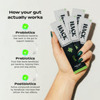Hand holding Hack Daily gut health supplement sachets with probiotics, prebiotics, and postbiotics for digestion and metabolism support